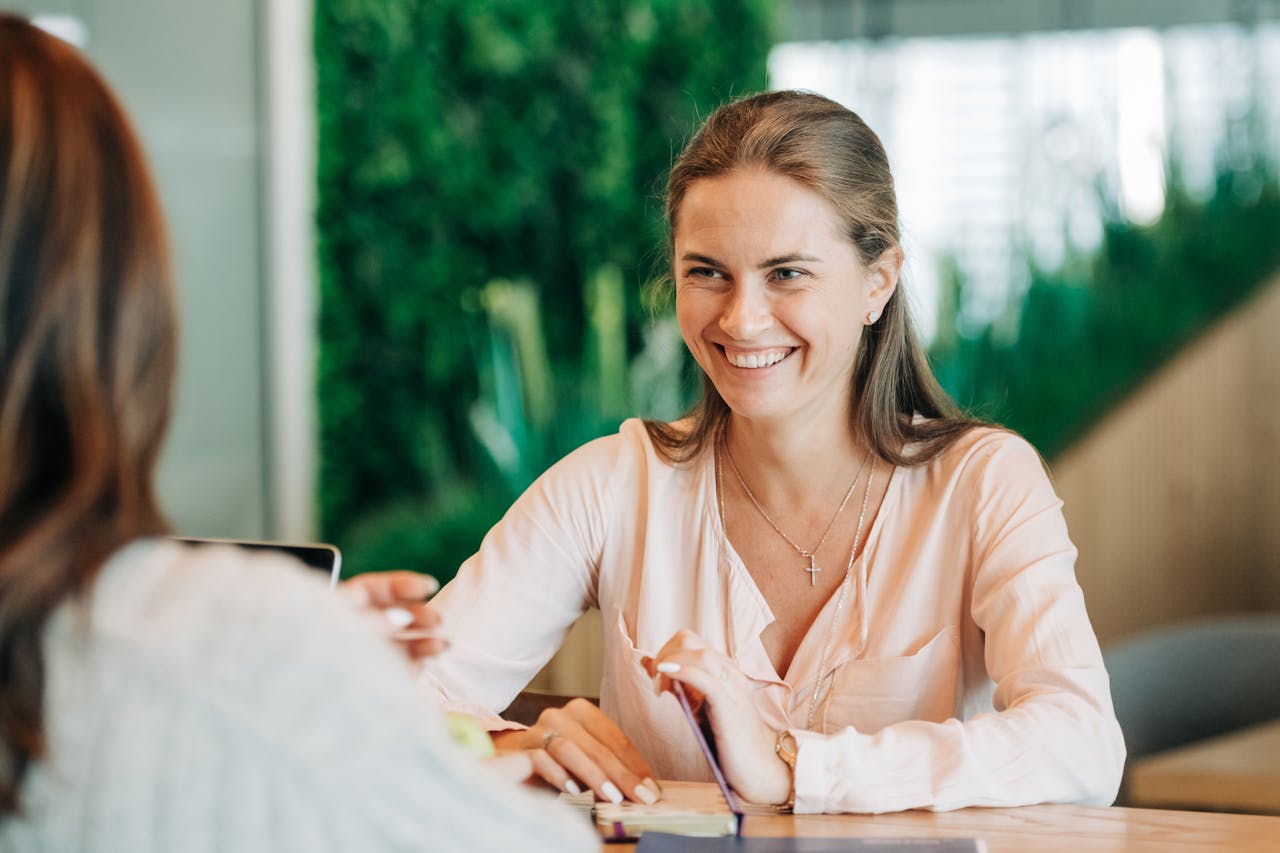 Young happy woman smiling and talking with colleague