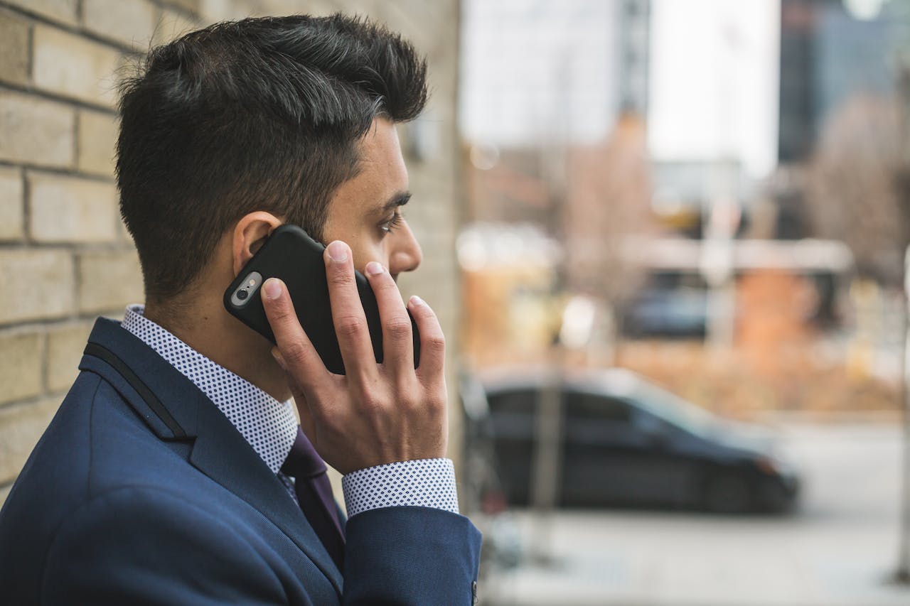 Man in Blue Suit Holding Smartphone
