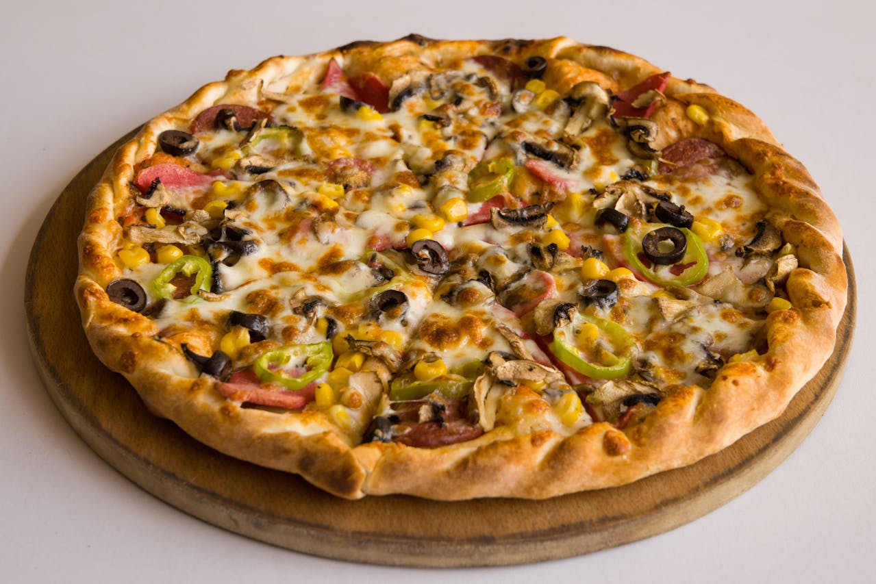 Close-up of Pizza With Meat and Vegetables Toppings