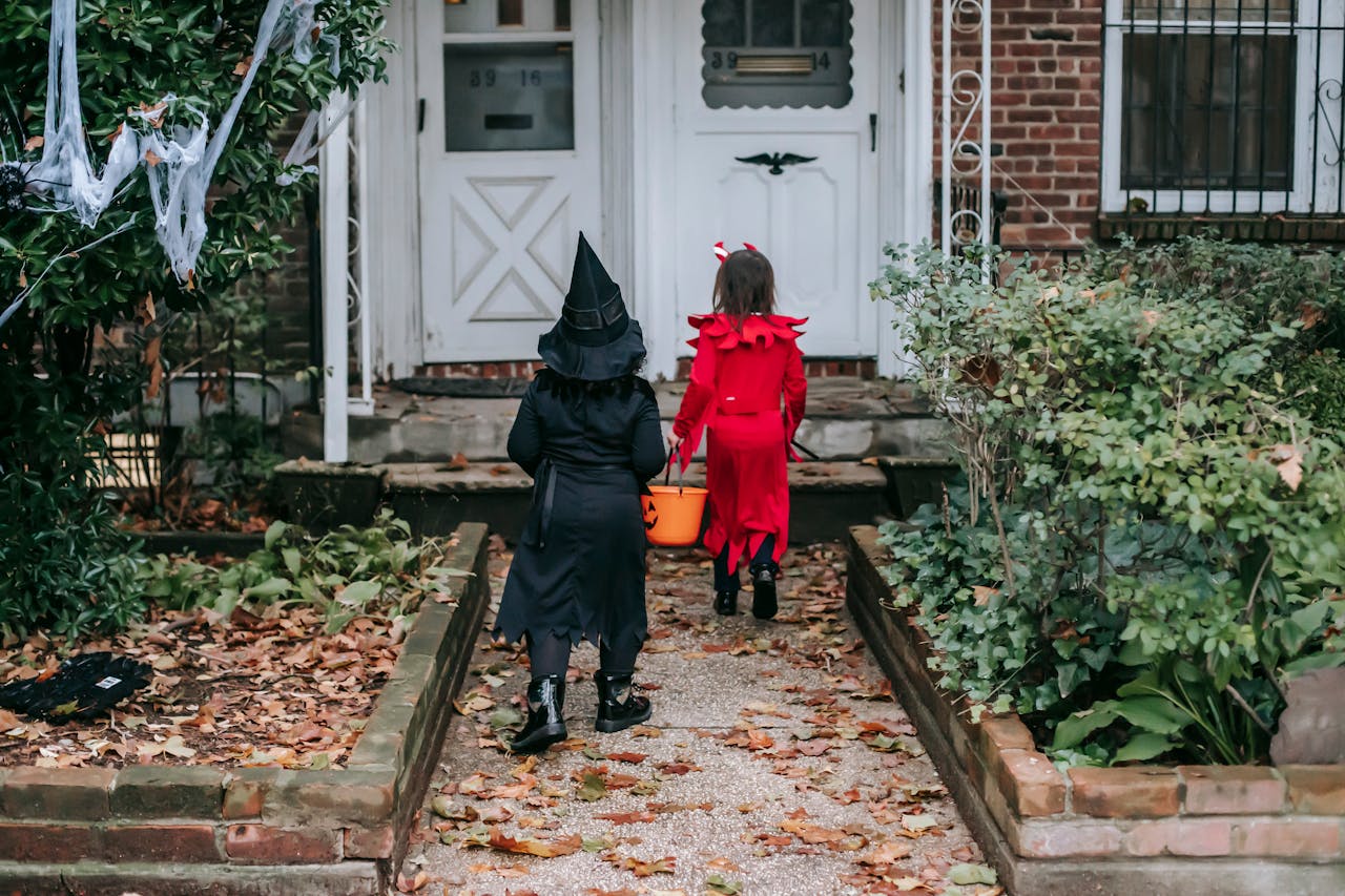 Kids in Halloween outfits playing trick or treat
