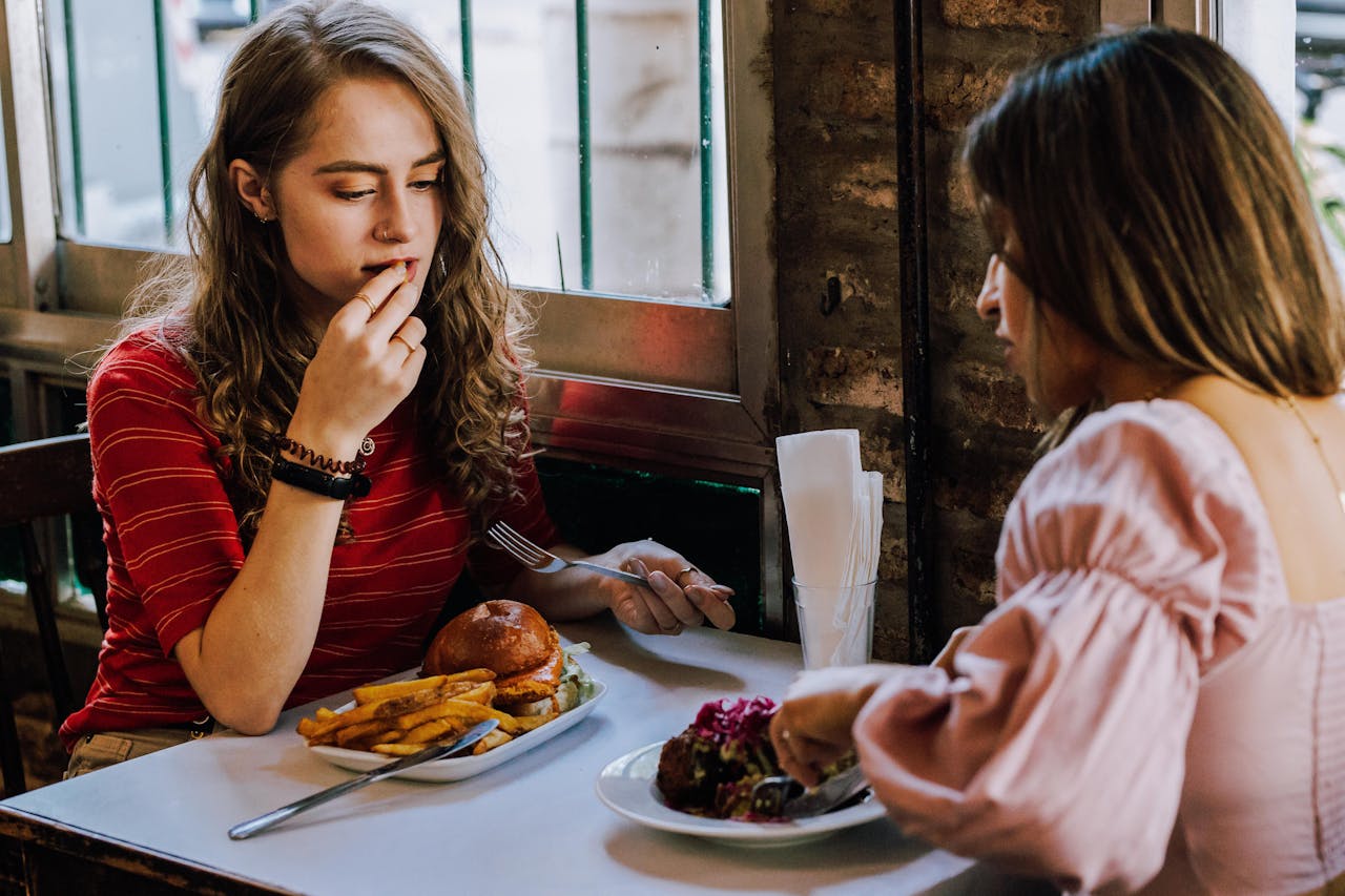 Women Sitting at Restaurant and Eating