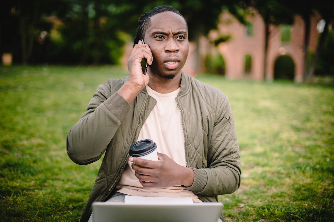 Young man with coffee talking on phone 