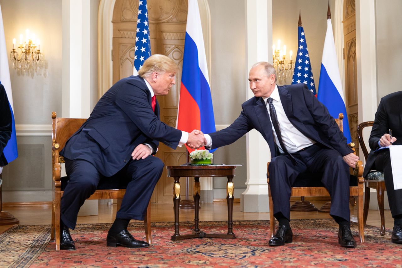 Shaking hands with Russian president Vladimir Putin during the 2018 summit in Helsinki, Finland