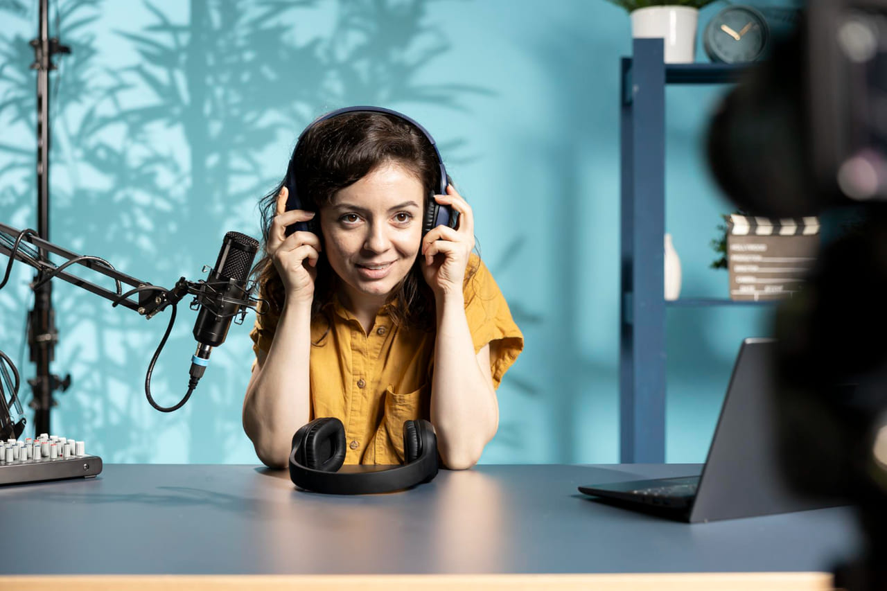 A student wearing headphones at a school desk with a ham radio rig, dials, and a small antenna visible.