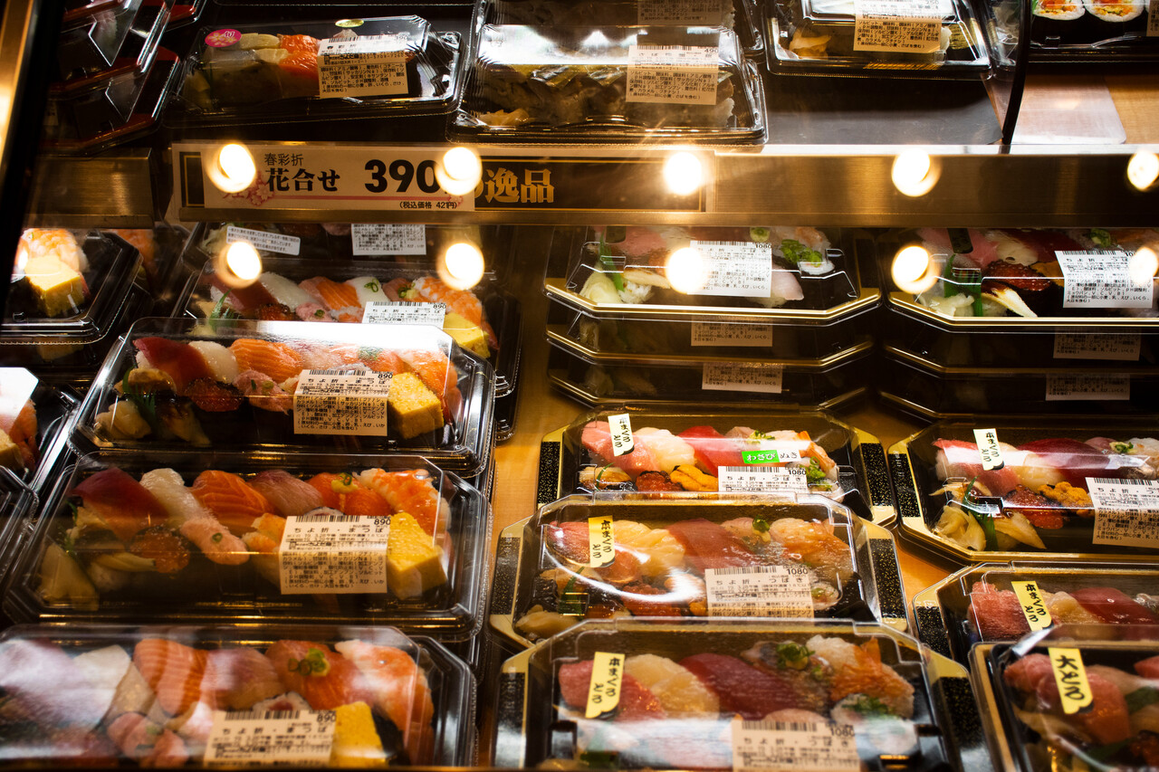 A bakery display case filled with allergen-labeled pastries.