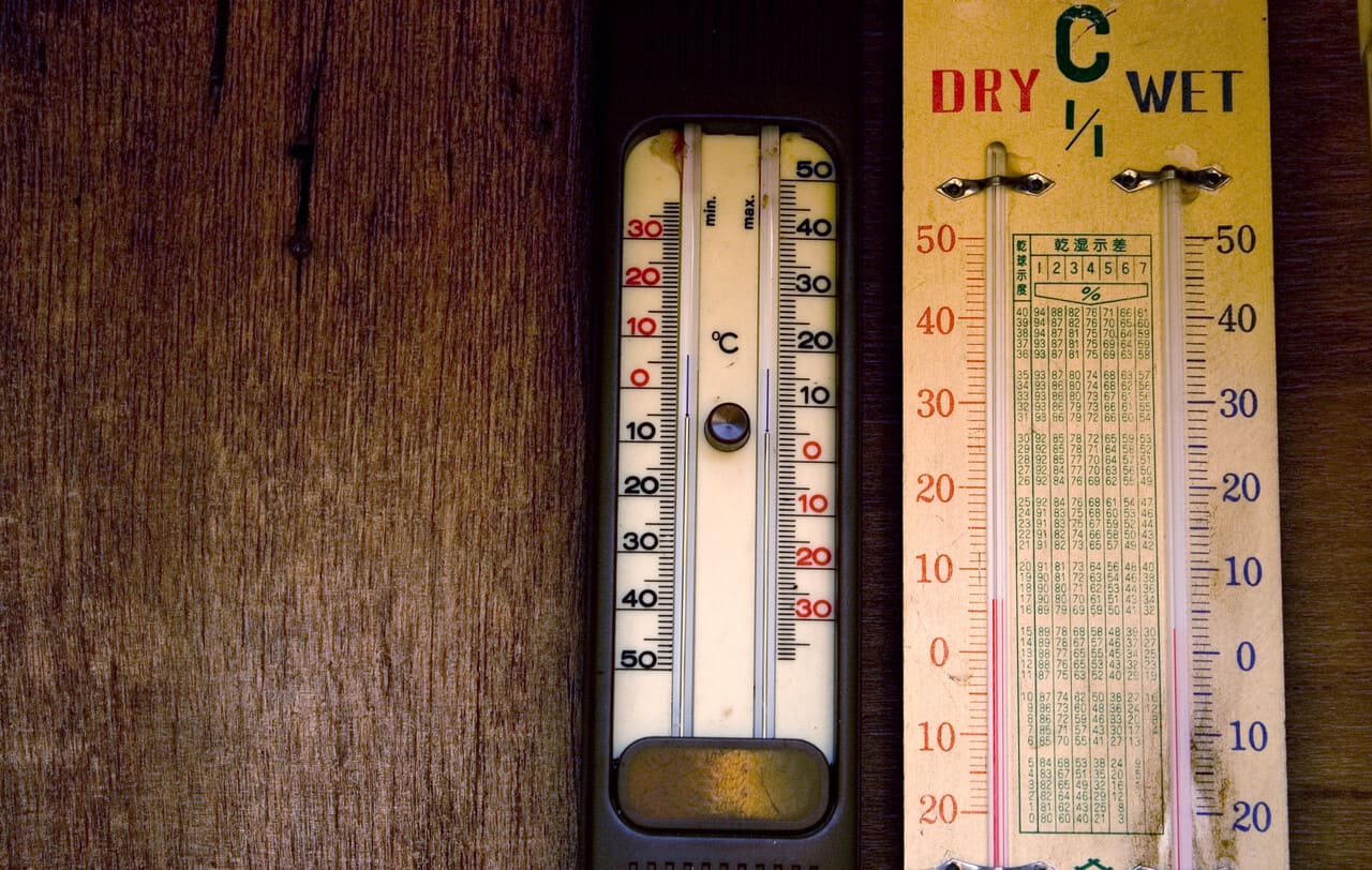 A close-up of old mercury thermometers on a science classroom table.