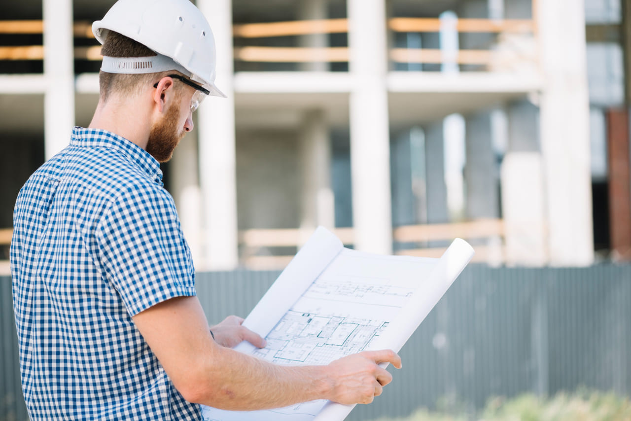 An engineer reviewing structural plans on-site.