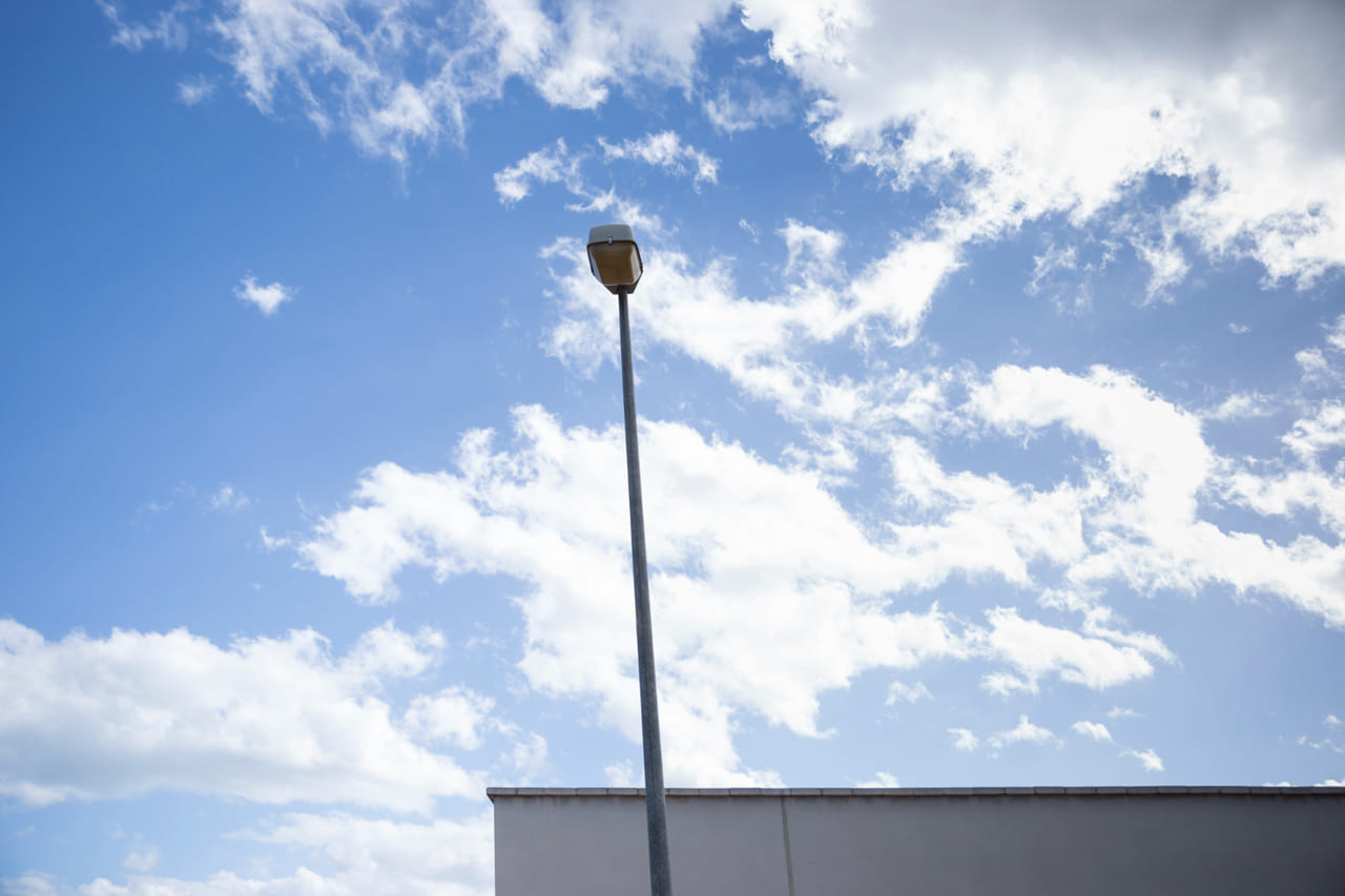 A bright outdoor security floodlight shining onto surrounding areas at night.