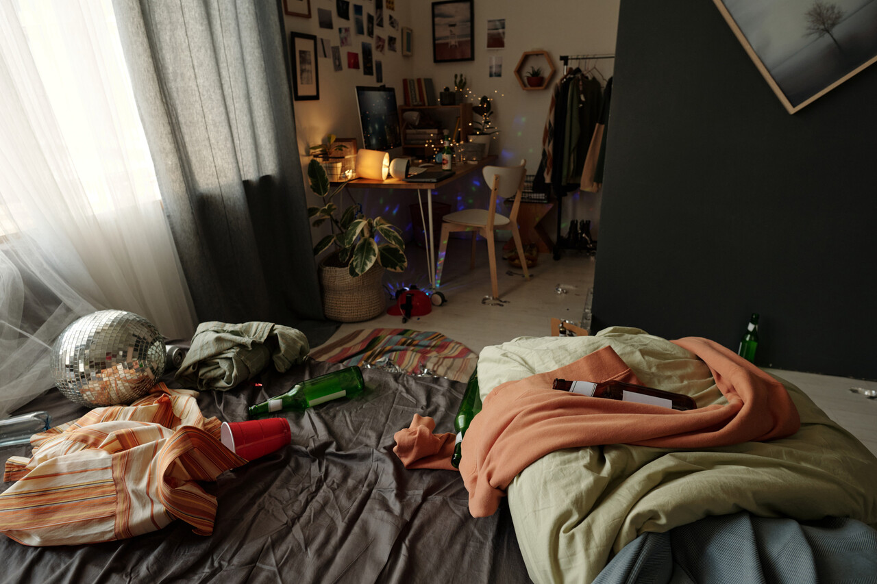 A wide archival shot of early 2000s pop culture items scattered on a bedroom floor.