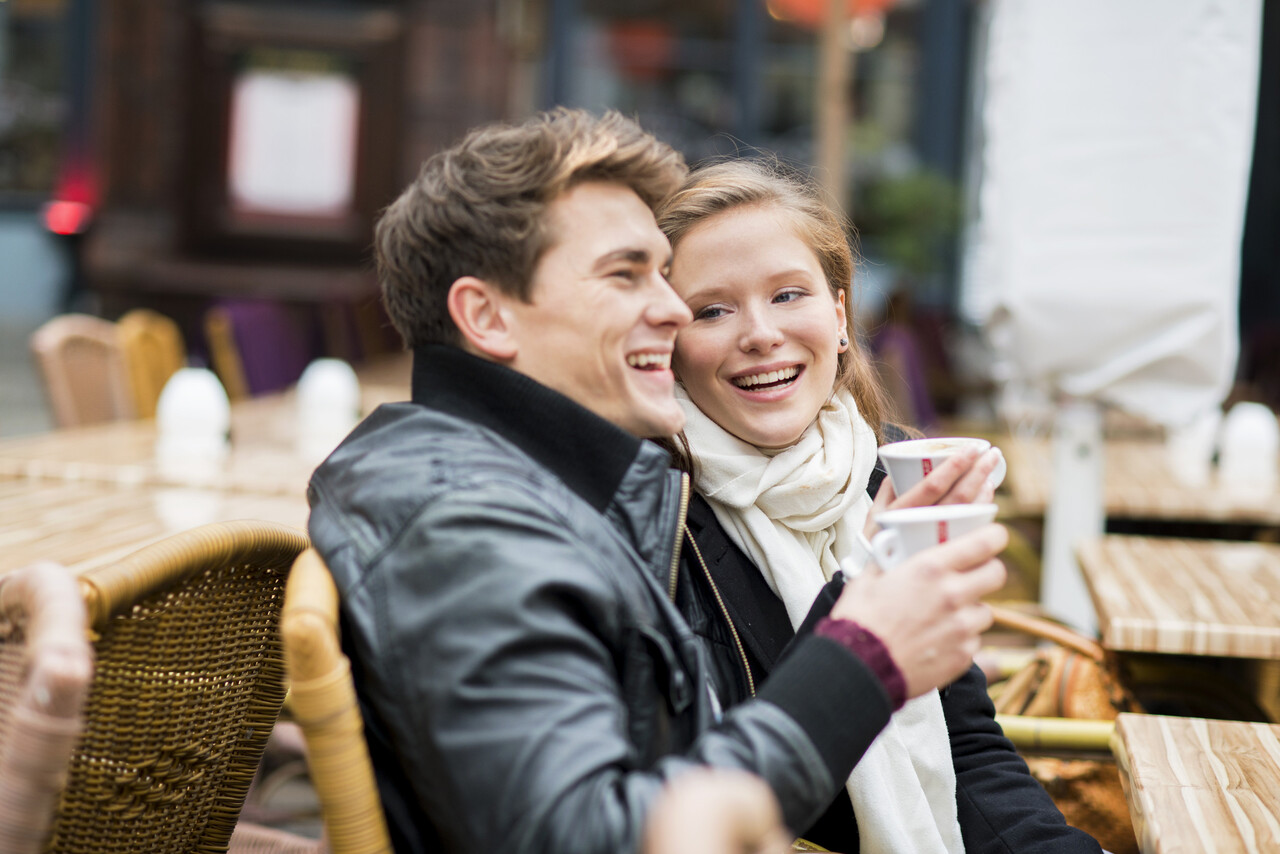 A vibrant market scene, a couple sitting at an outdoor café,