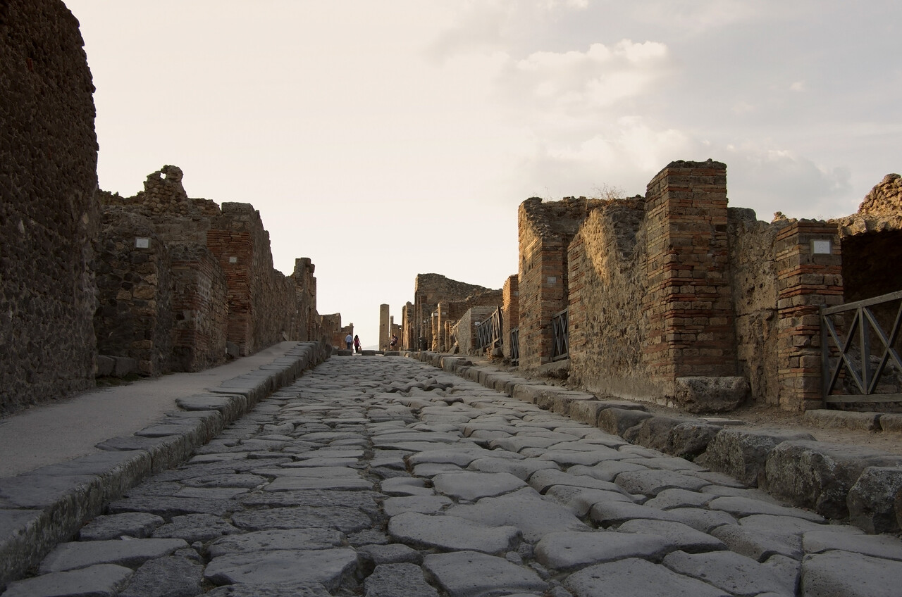 view of an ancient city ruin partially covered by vegetation,