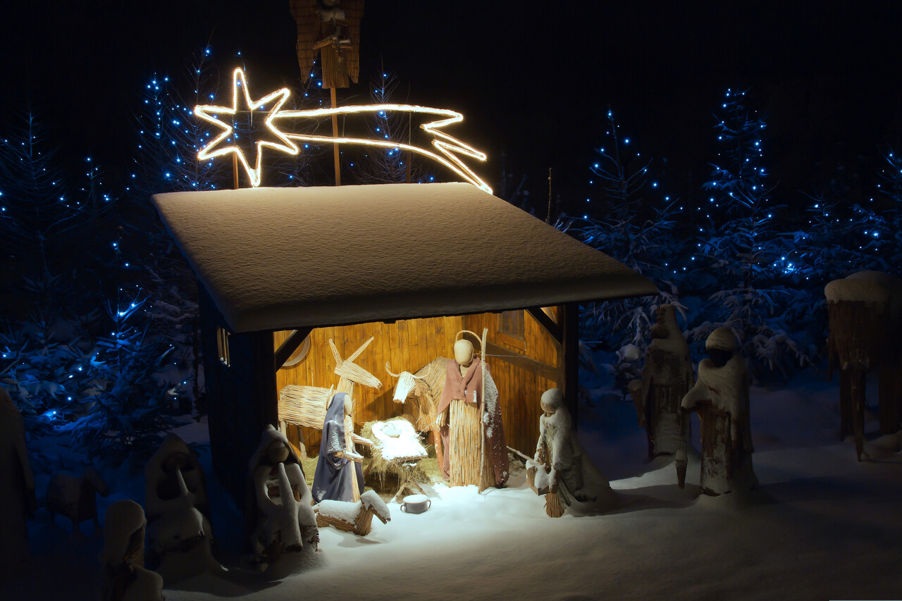 A traditional nativity scene with the Magi approaching from a distance.