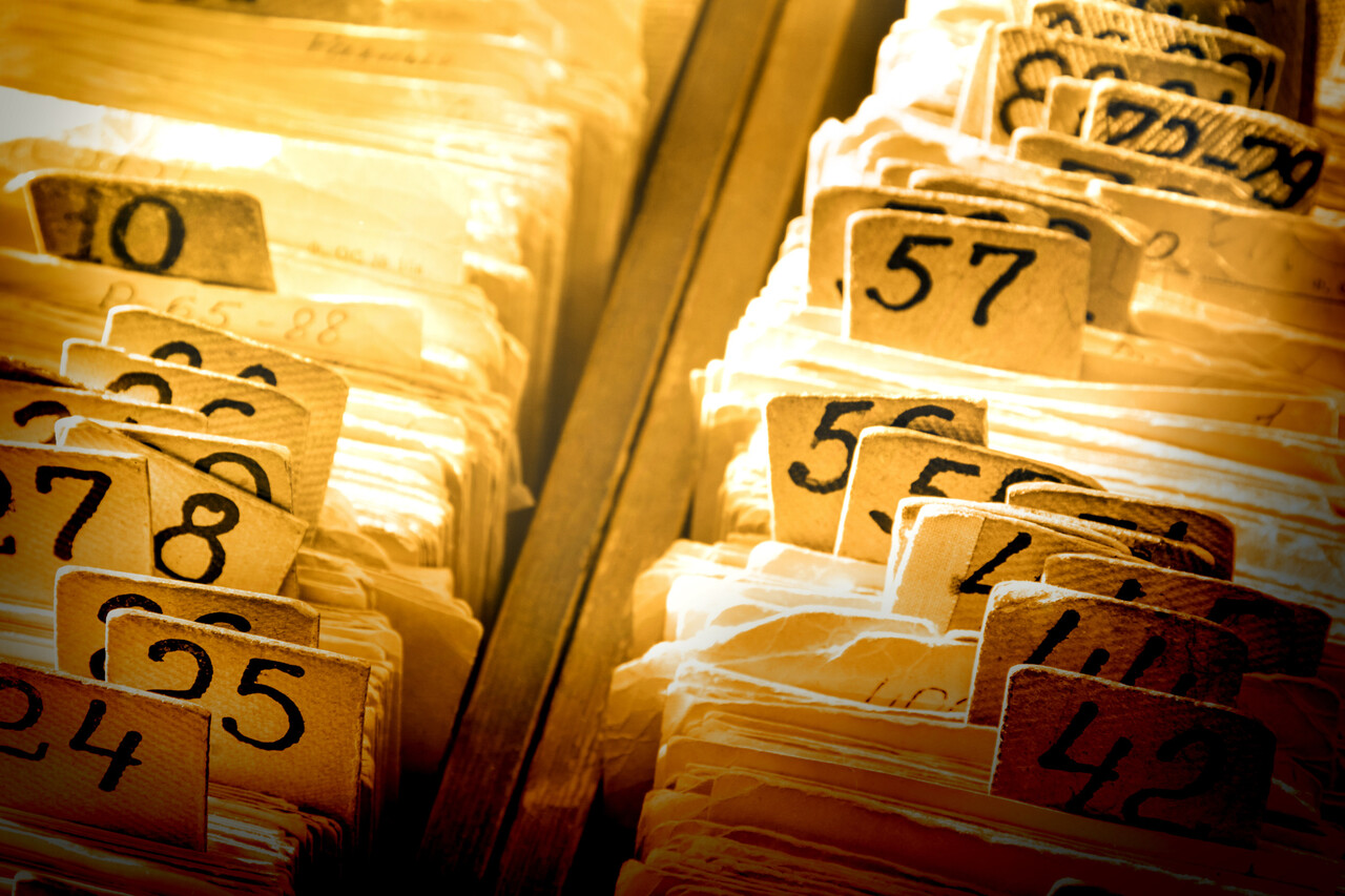 Photograph of identification cards or numbered inmate records photographed for administrative processing.