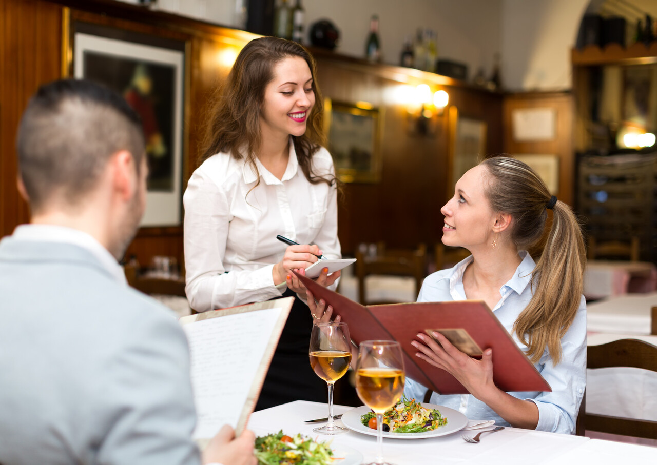 Close-up of a server smiling and making eye contact with a guest.