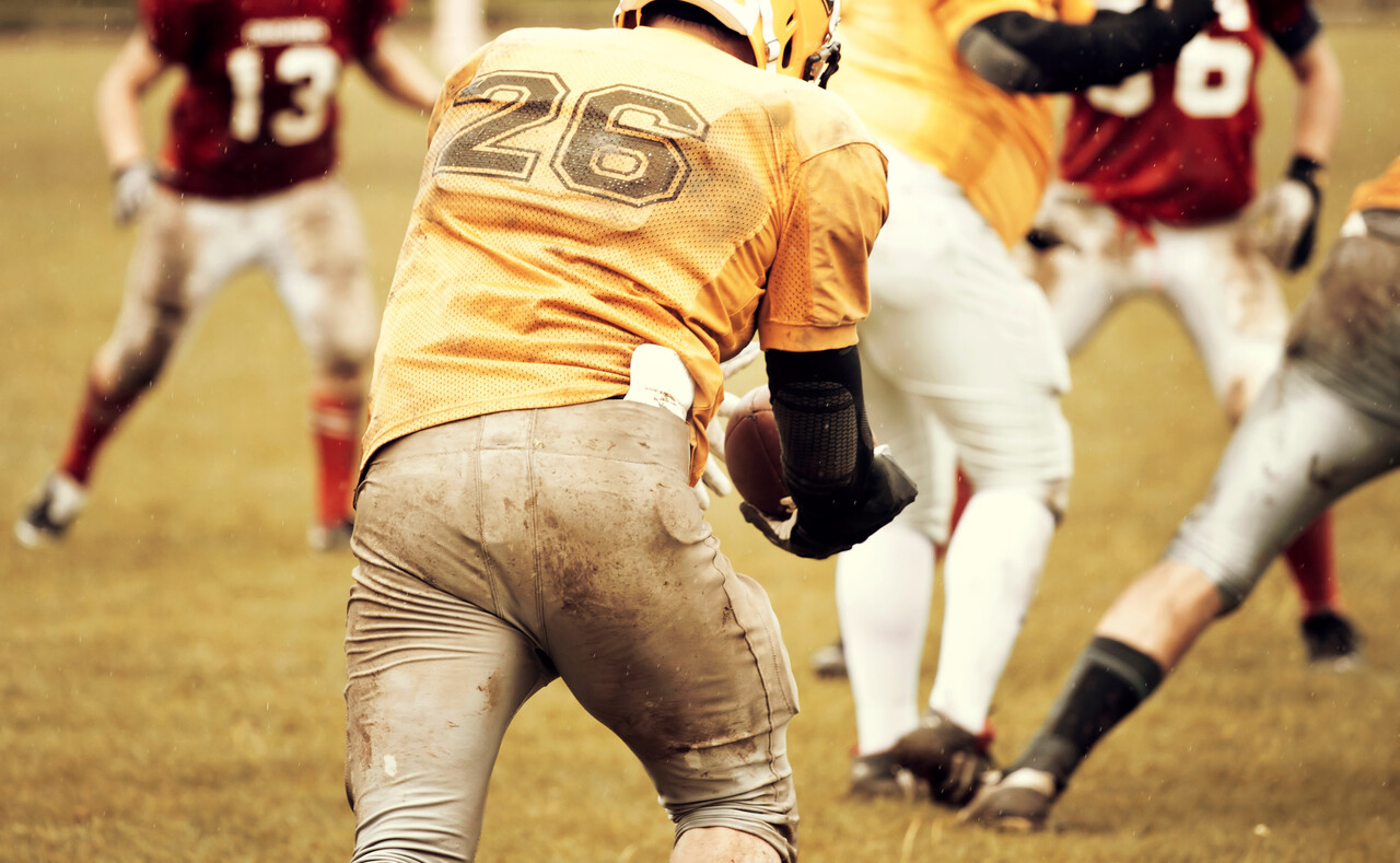 An NFL player walking into a stadium on Christmas Day wearing team gear, holiday decorations visible outside.