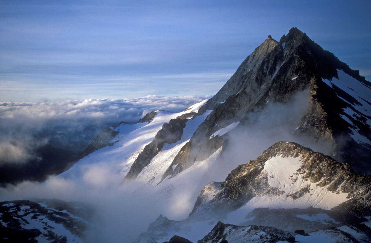 Mountain peak poking through the clouds at dawn