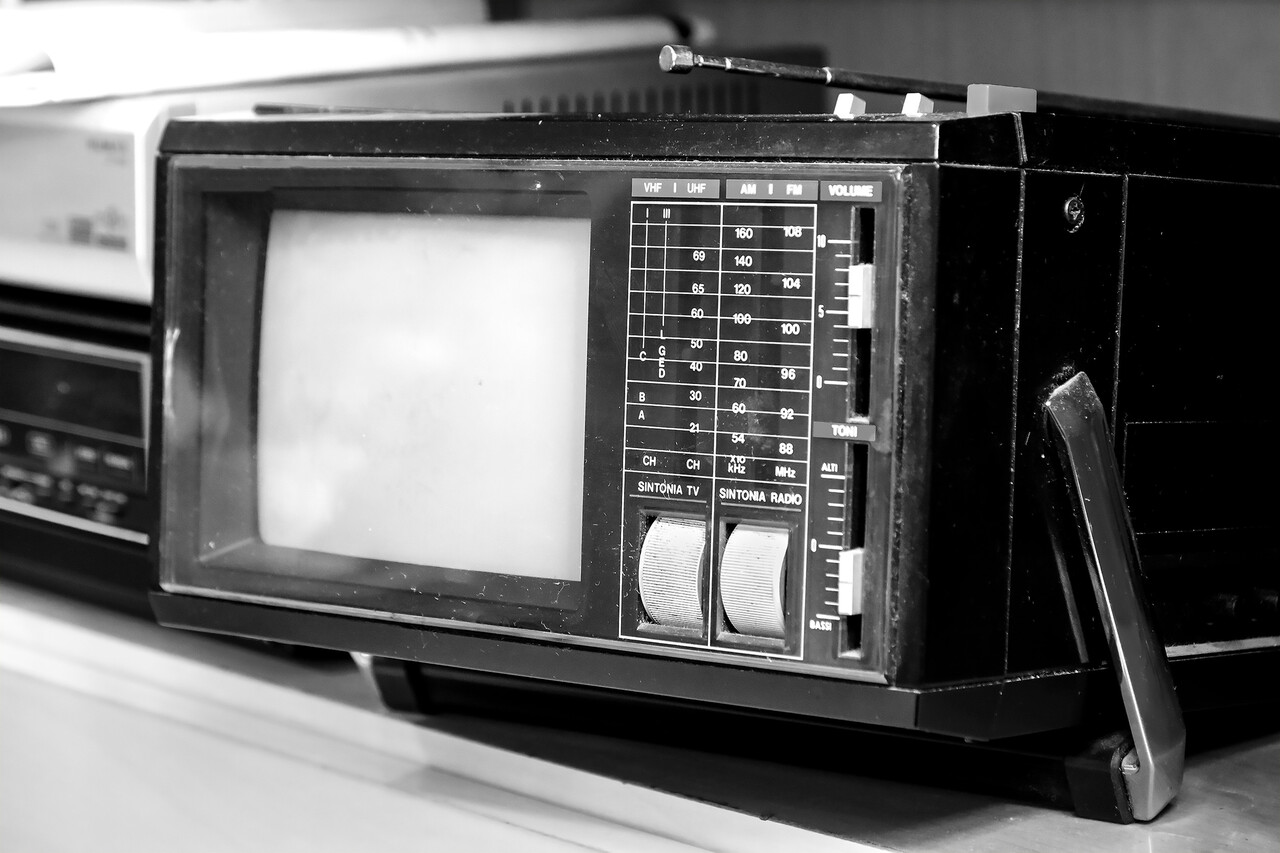 An archival-style shot of early television control panels with a script labeled for a holiday drama resting nearby.