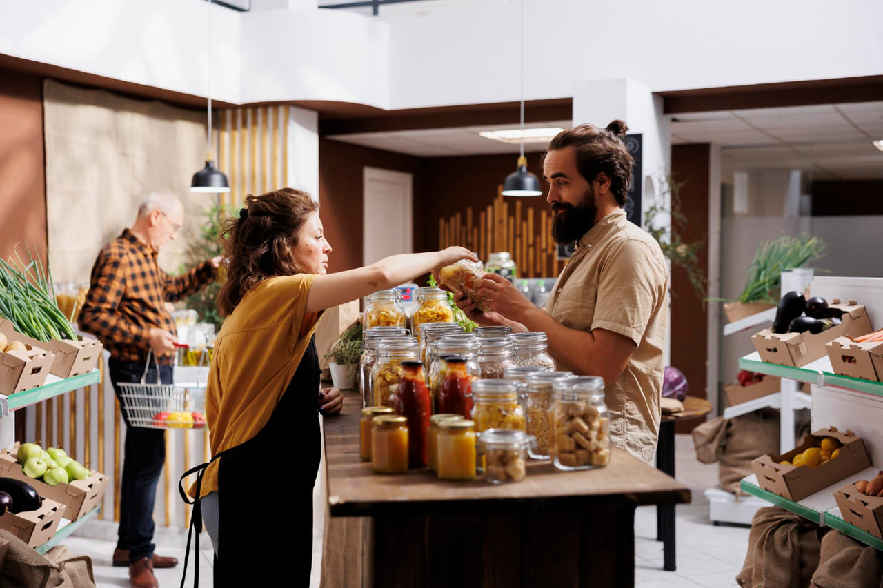 A close-up of a family-run shop or restaurant owner preparing food, arranging goods, or greeting customers.