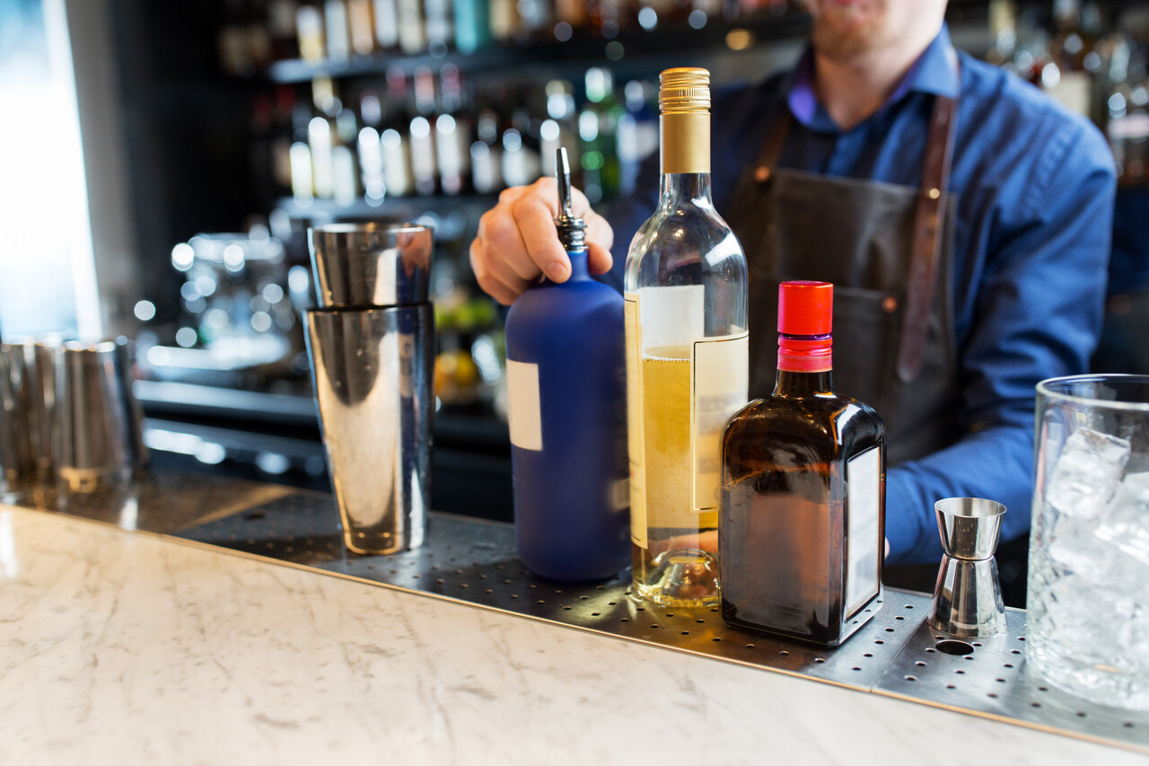 A bar counter showing infused alcohol behind the register.