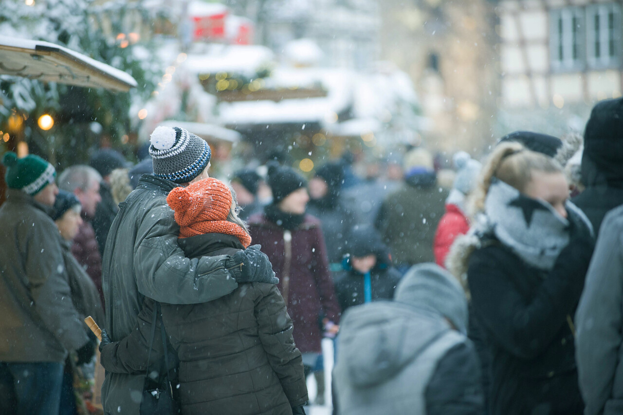 A vintage illustration of a crowded winter street scene with revelers causing mischief