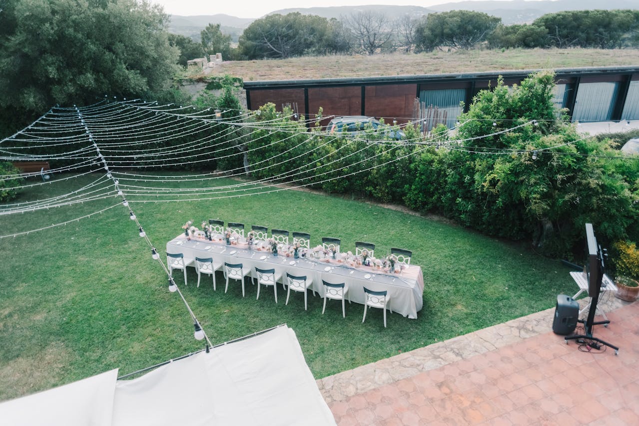 A backyard gathering setup with speakers or outdoor string lights before a party begins.