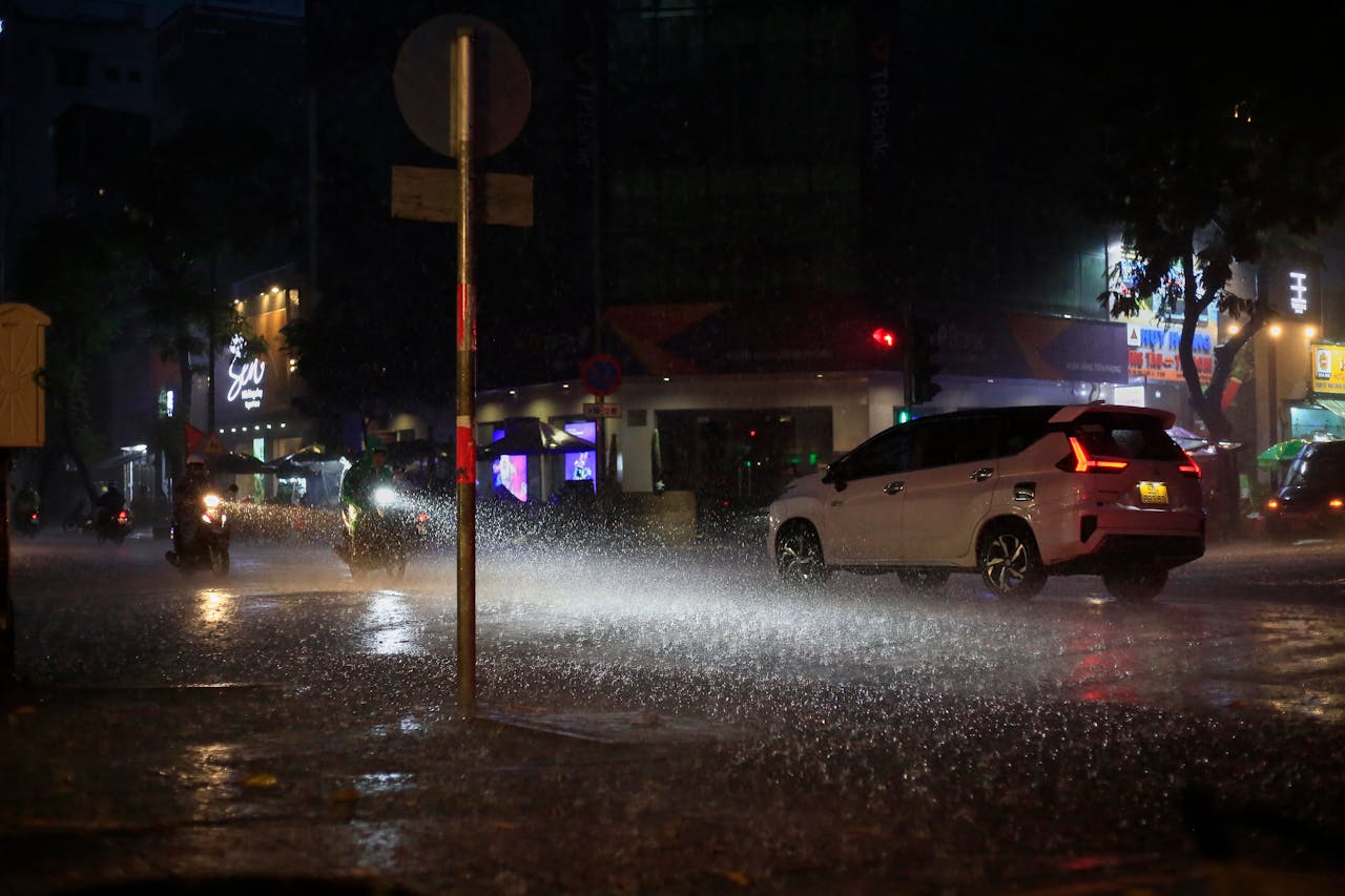 Cars with hazard lights flashing in heavy rain.