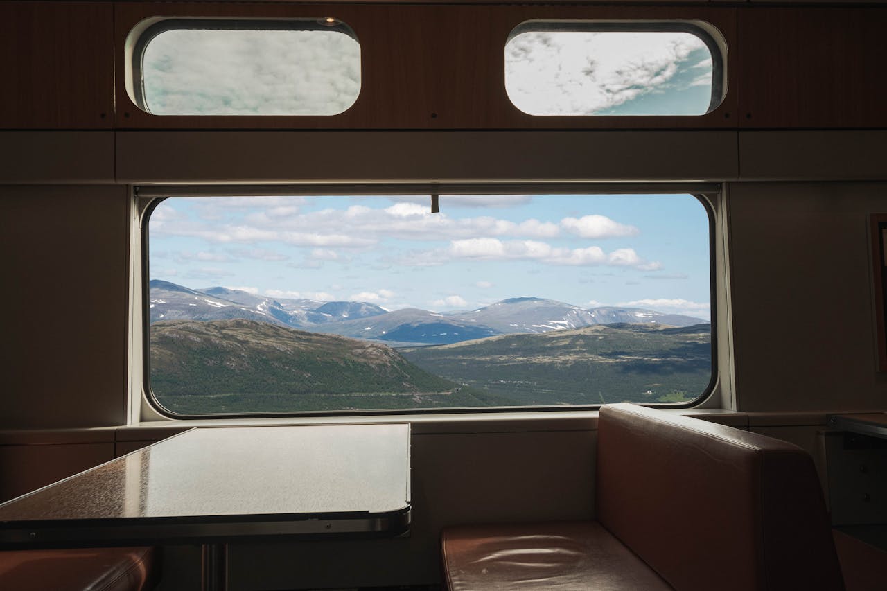 A scenic shot taken from inside a train window showing rolling European countryside