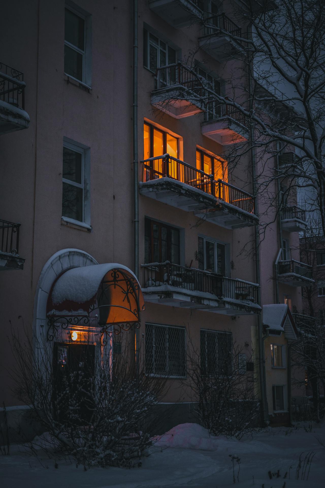 A quiet Swiss apartment building courtyard or entrance at dusk, emphasizing calm residential life.