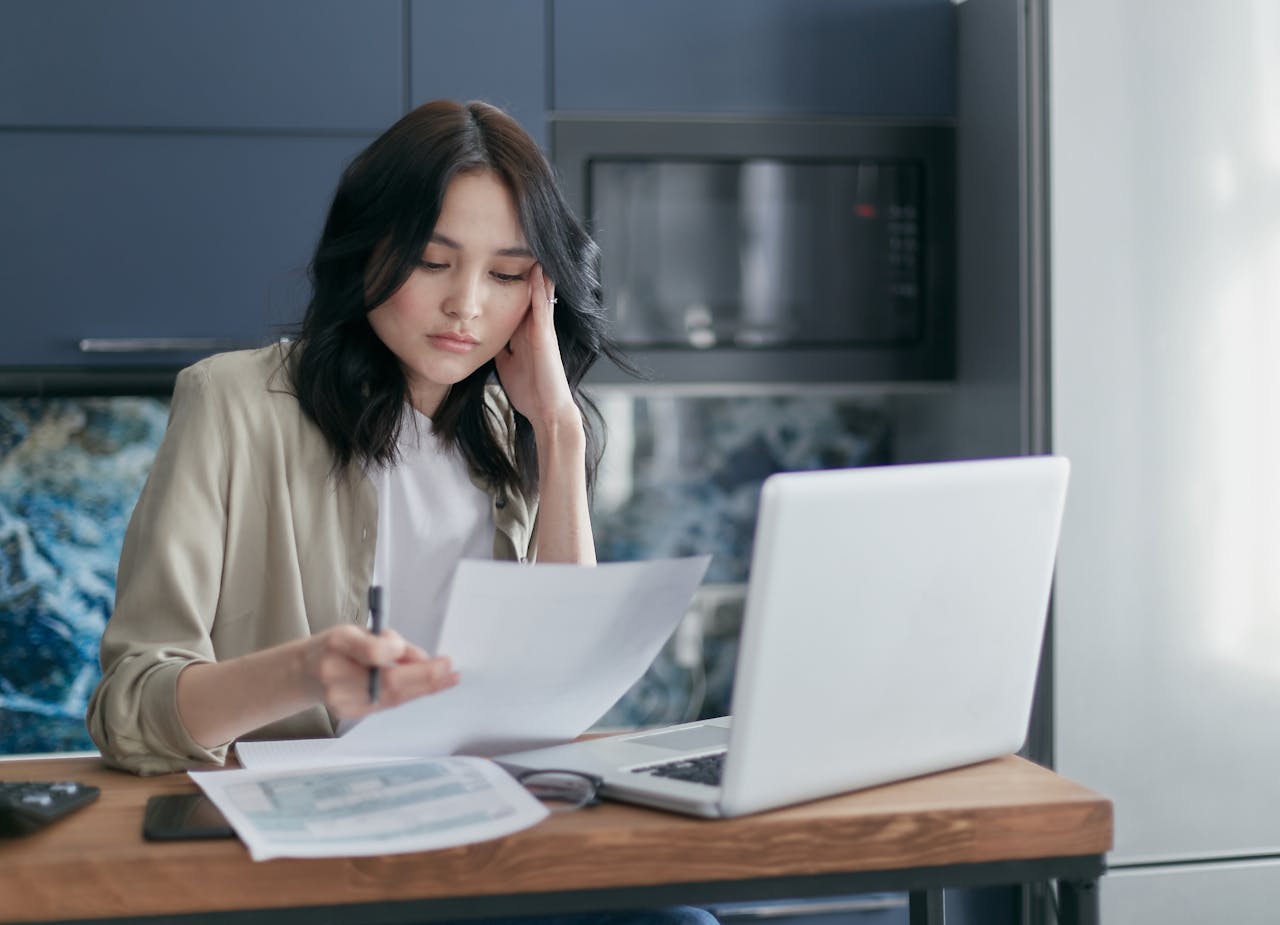 Person reviewing a home budget with a laptop.