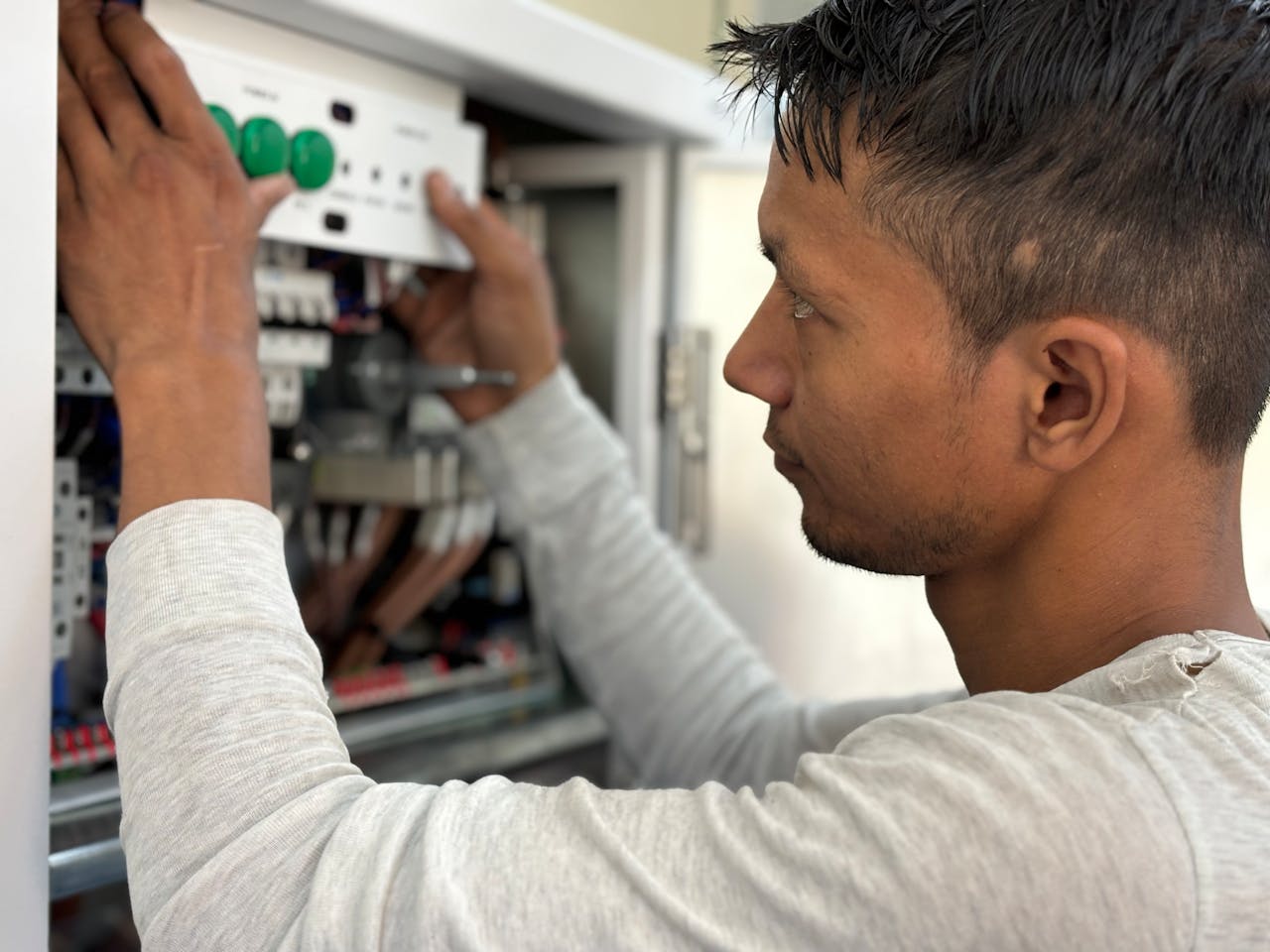 An electrician working on a breaker panel.