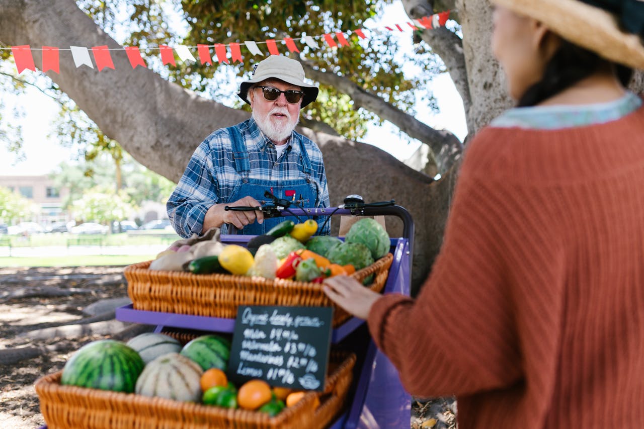 A warm, natural conversation scene between a traveler and a local artisan, vendor, or elder.