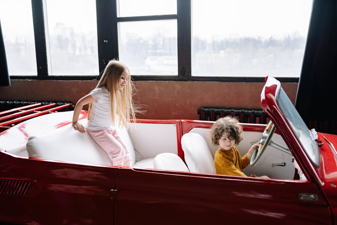 A retro family car interior from the 1960s or 70s with kids sitting freely.