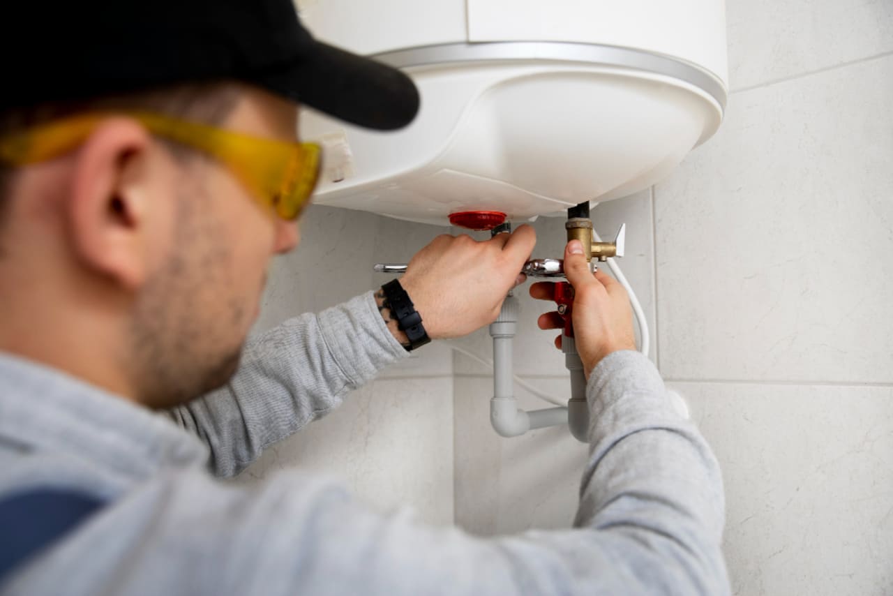 A plumber installing a standard tank water heater.