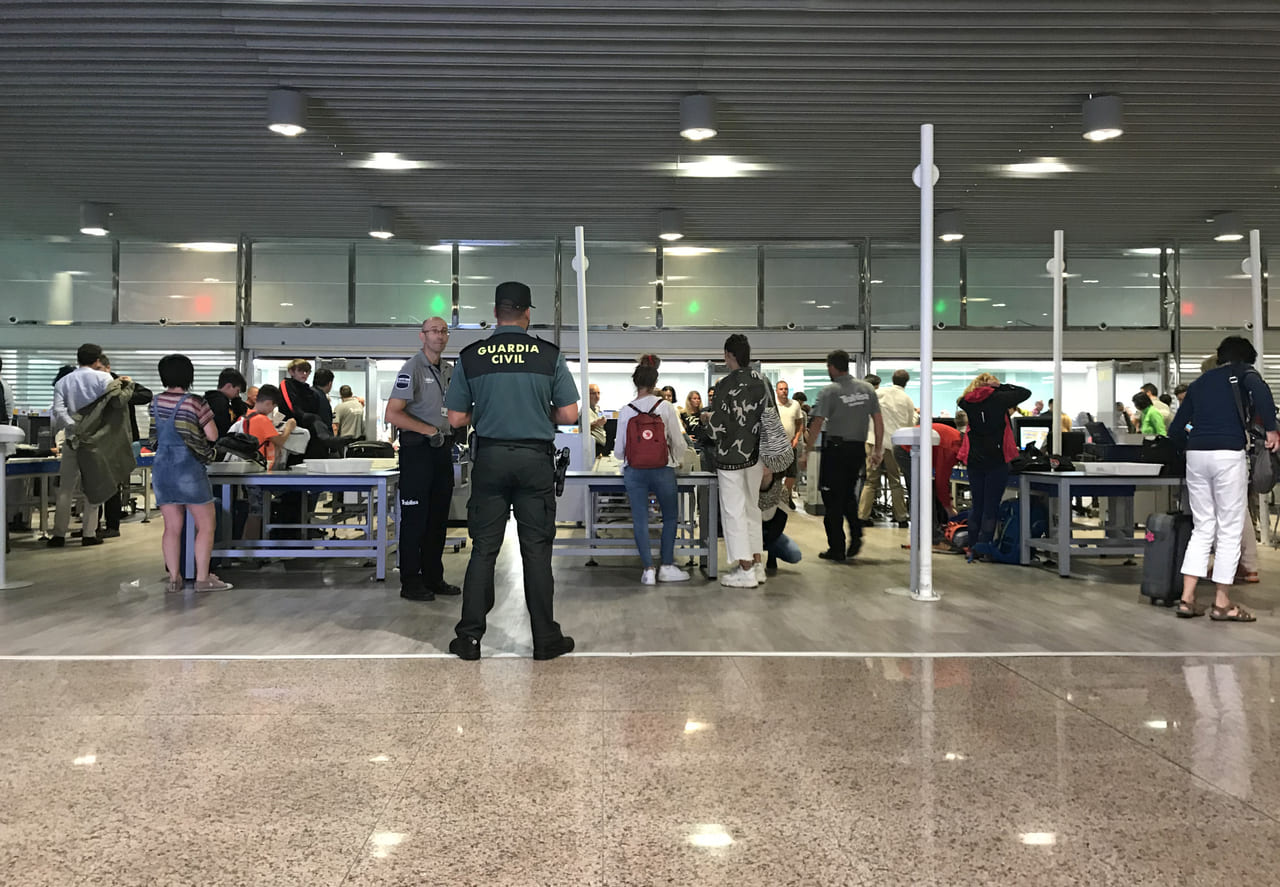 A customs officer inspecting food items at an international airport checkpoint.
