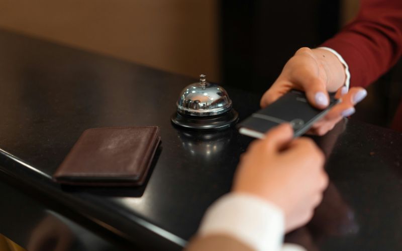 Hotel front desk displaying local tax fees on check-in screen