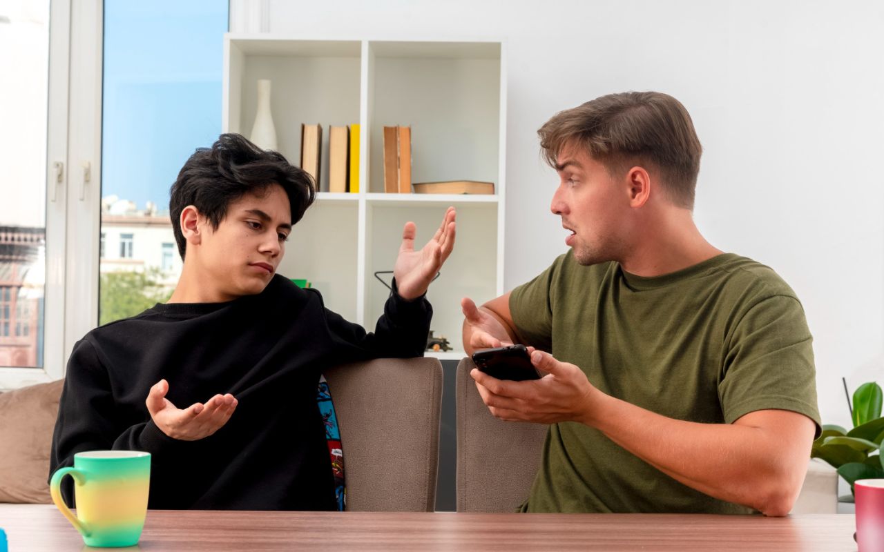 Person looking hurt while another gestures dismissively during a conversation