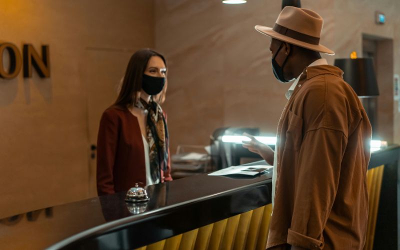 Guest speaking with hotel front desk about early check-in fees