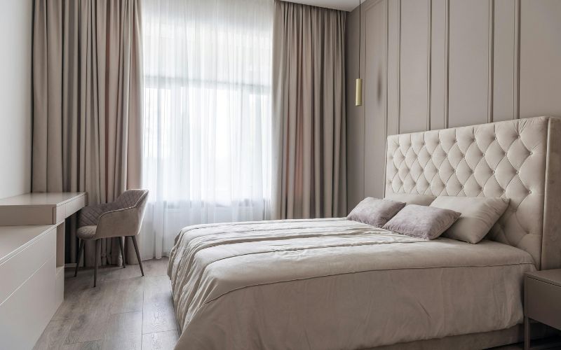 Bedroom with neutral pleated window curtains