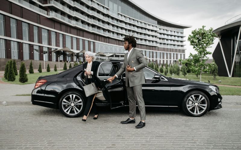 Tourist paying driver for hotel shuttle service outside airport