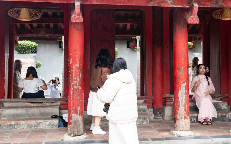 Tourist wearing casual clothing at a temple with locals in traditional dress