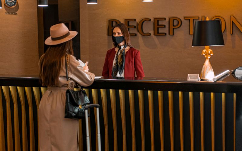 Hotel lobby with a resort fee sign and a guest checking in