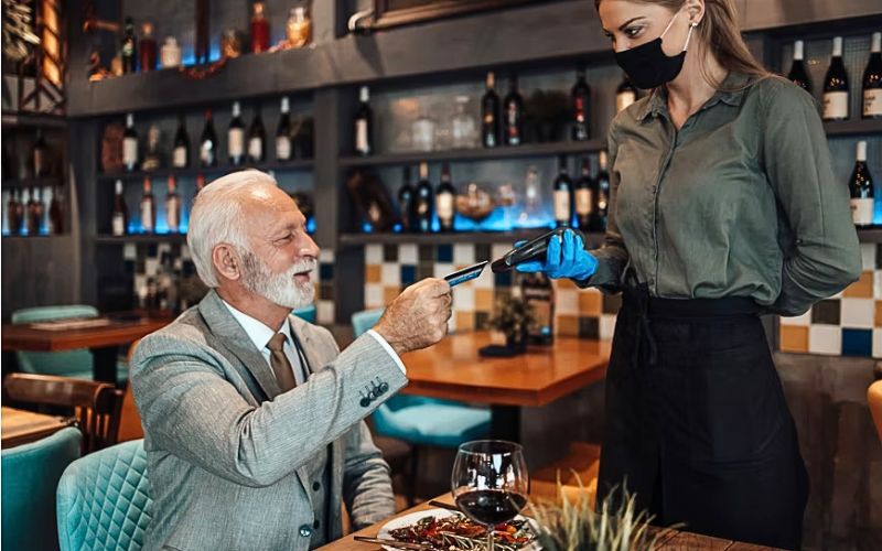 Tourist tipping a waiter incorrectly