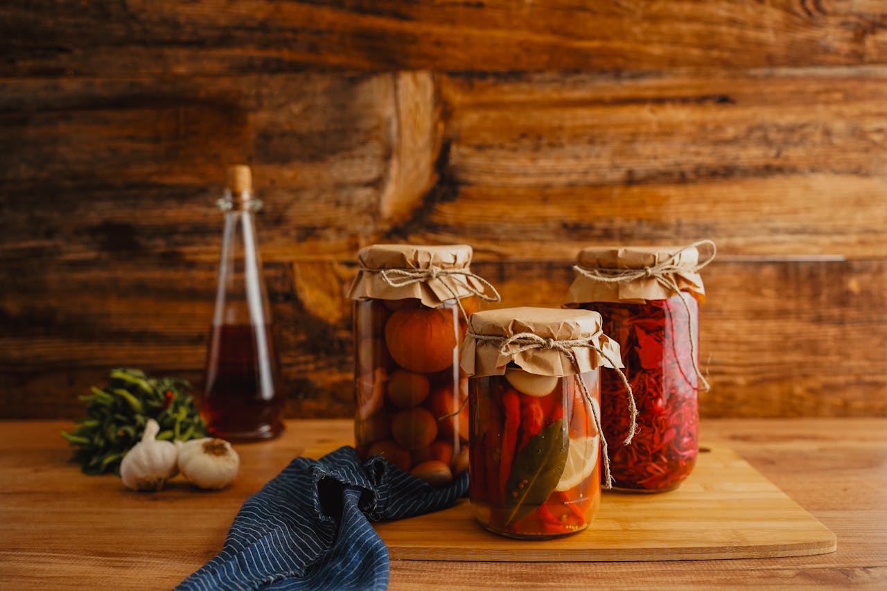 Jars of preserved lemons, pickled cherries, and fruit-based ferments.