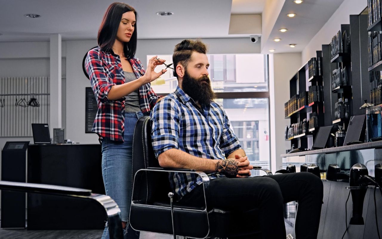 Client sitting still during a haircut, showing proper posture that helps stylists achieve precise results.
