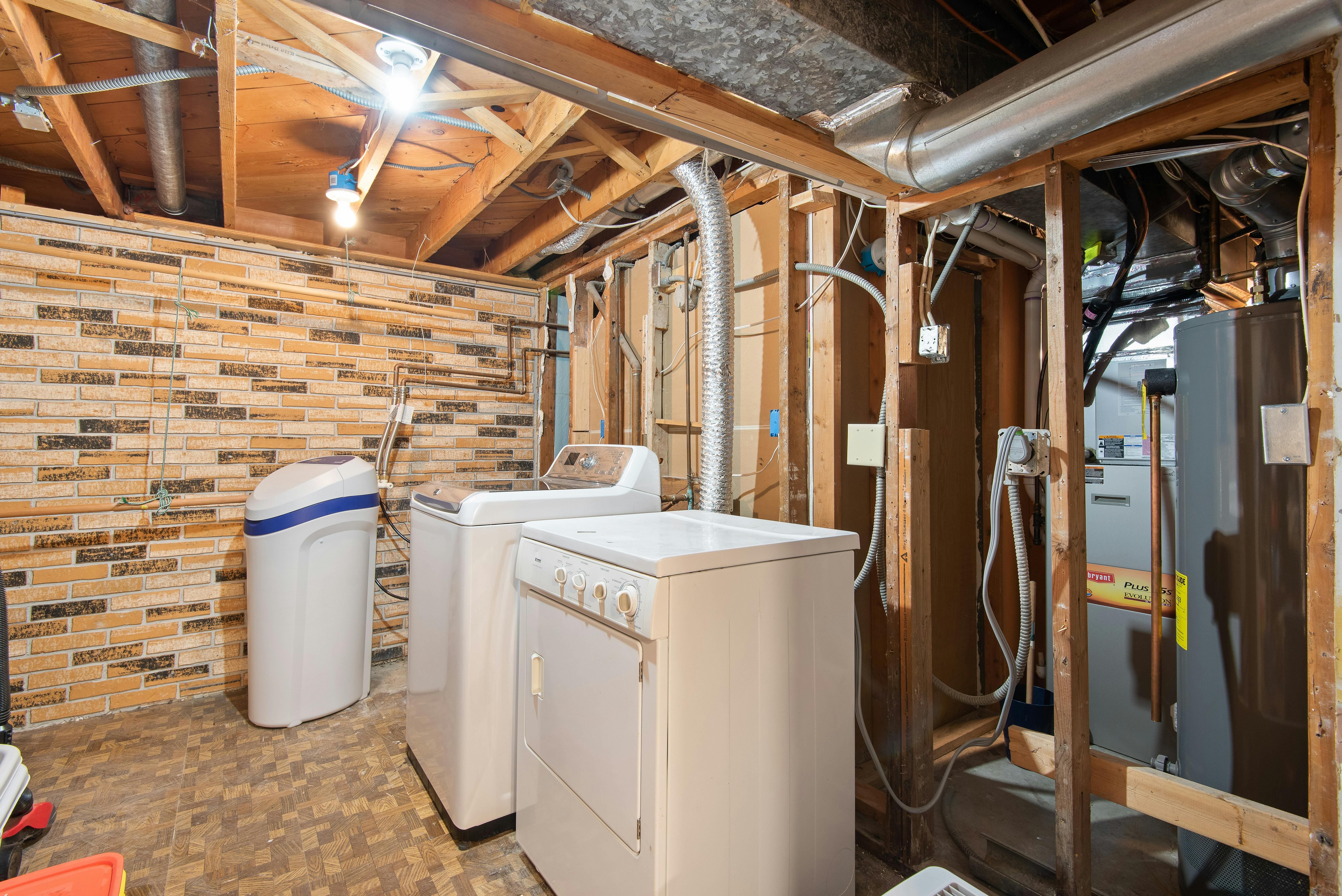 Damp basement corner with exposed pipes, illustrating areas where musty odors often originate.