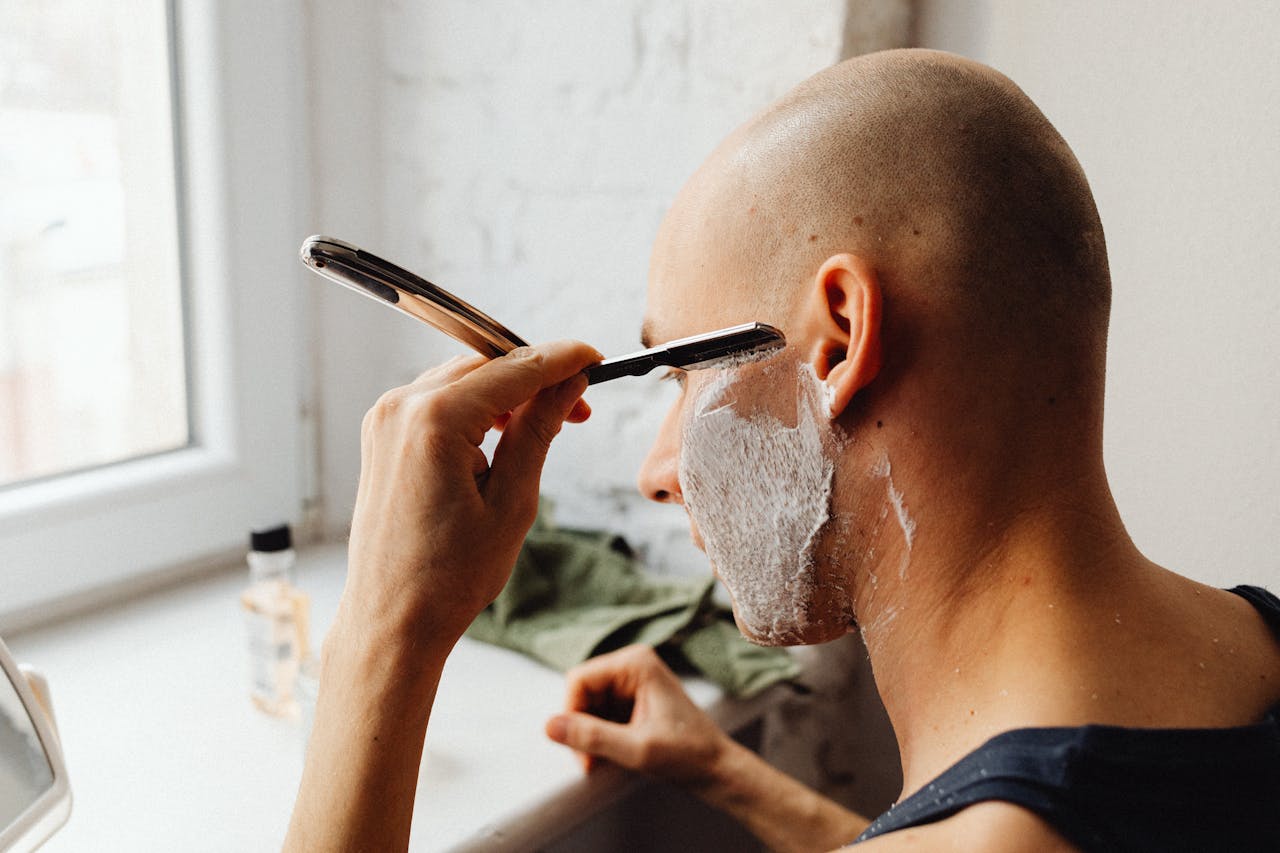 Person attempting to thin hair with a razor at home