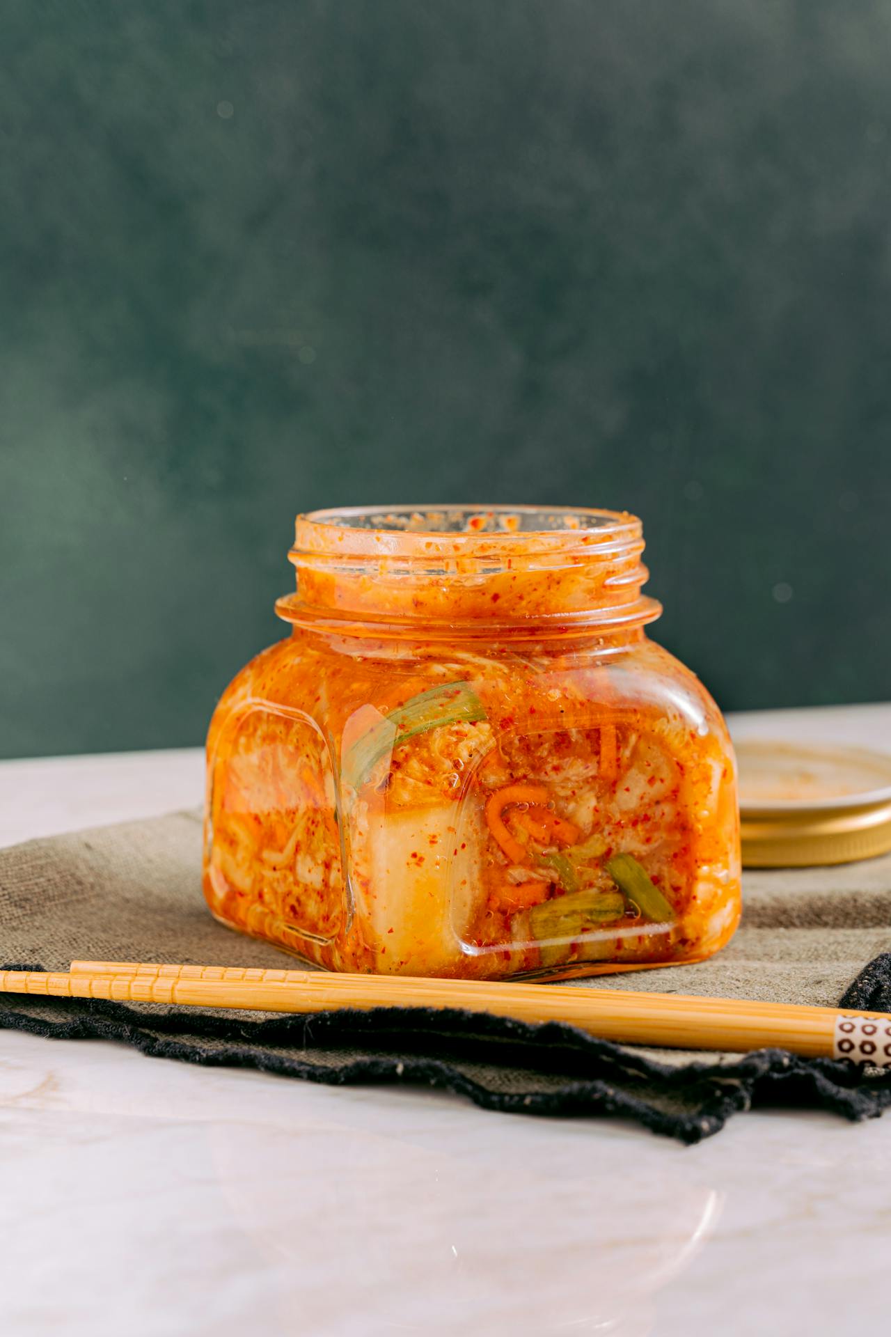 Jar of kimchi and glass of kombucha showcasing bold, tangy fermented foods.
