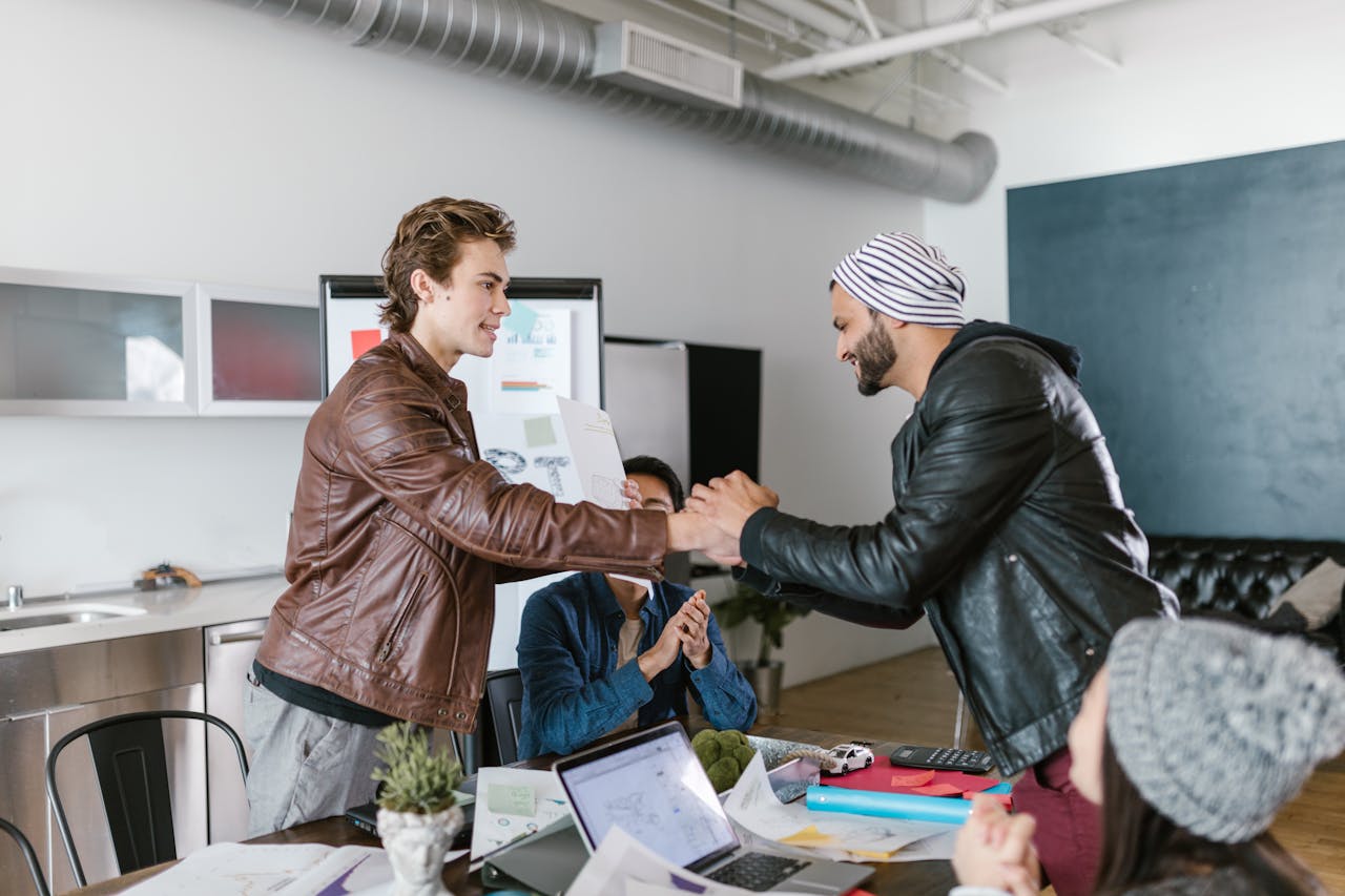 Two colleagues shaking hands, one offering a limp grip while the other looks unsure or disengaged.