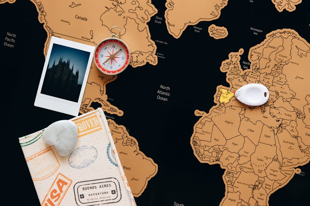 A world map with several countries subtly darkened or shaded, a U.S. passport placed in the foreground on a table, and an airport departure board blurred in the background to suggest restricted travel.