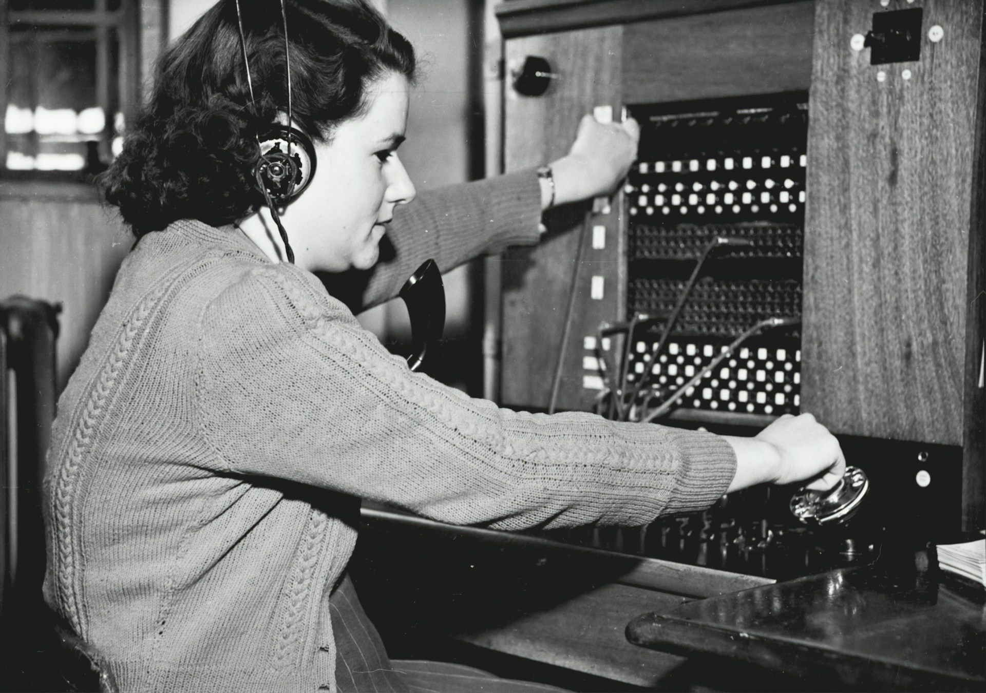 Operators managing multiple lines, logging messages, and connecting calls in a World War I communication center